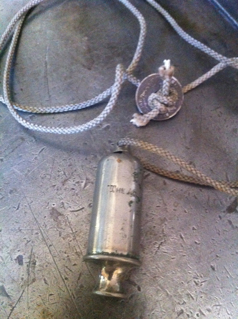 Vintage siren whistle on vintage rope with vintage coin closure