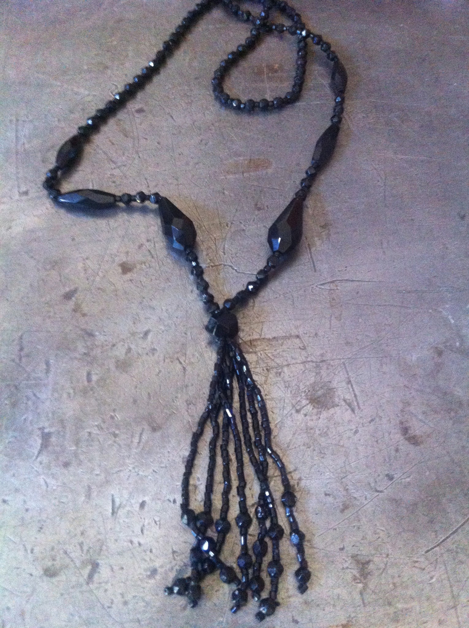 Sold at Auction: A vintage jet necklace, composed of graduated faceted  beads, to a white metal screw barrel clasp, 43cm long, 56gms CONDITION:  wire strung, so hangs with a twist. Clasp fine.